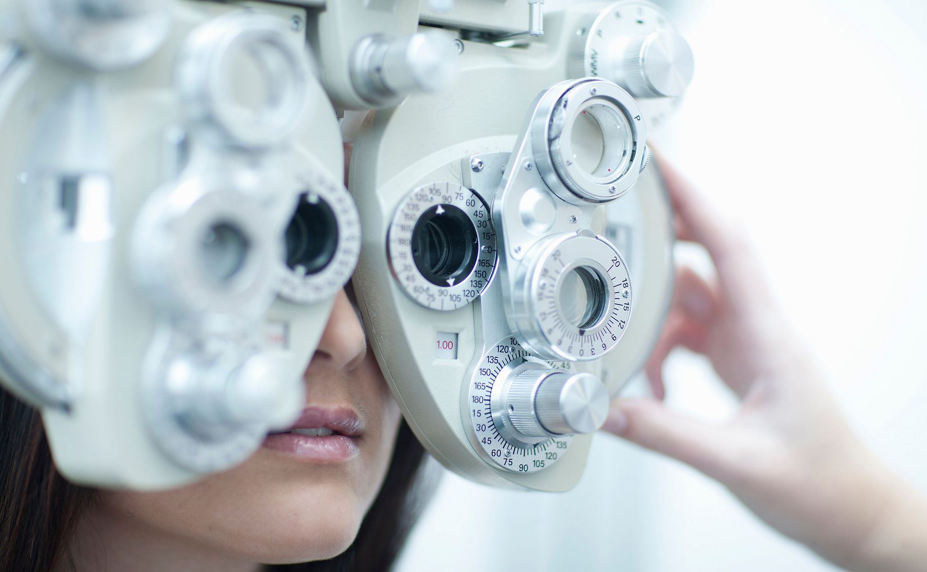 Patient looking through a phoropter during an eye exam