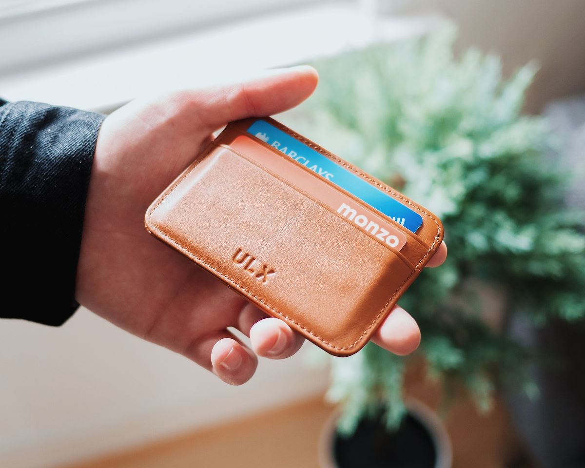 Hand holding a wallet with a payment card